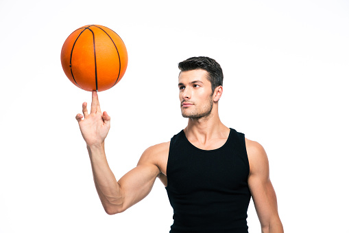 Basketball player spinning ball on his finger isolated on a white background