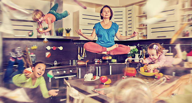 It's time to fly away Mother meditating at the kitchen with her children flying around chaos stock pictures, royalty-free photos & images