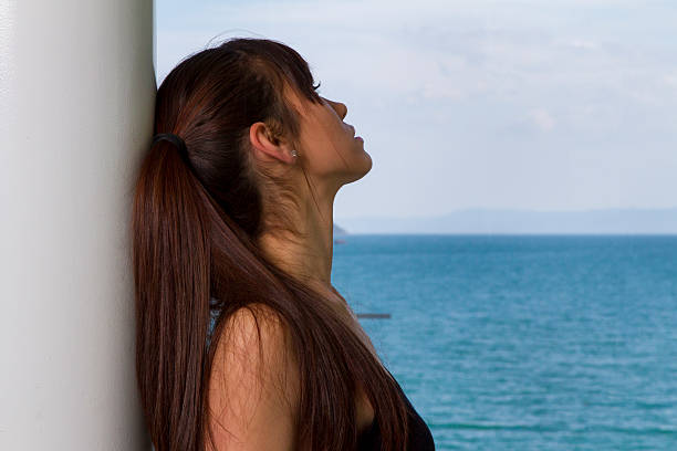 femme regardant longingly sur la mer - longingly photos et images de collection