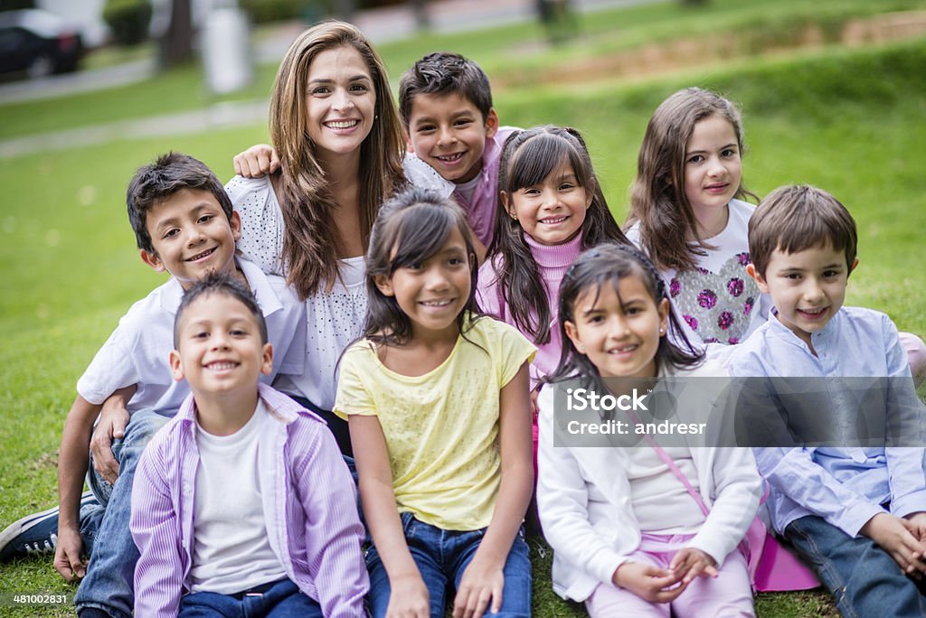 Happy teacher with her students Female teacher in a group picture with her students Adult Stock Photo