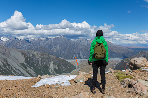 Female hiker looks out at view above glacier