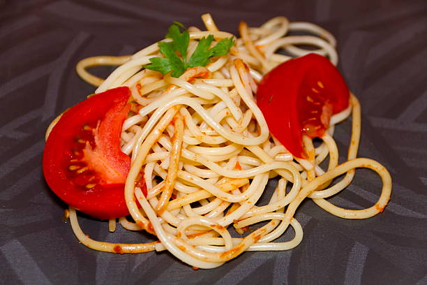 frescos de cozinhar esparguete com vermelho tomate e salsa - teigwaren imagens e fotografias de stock