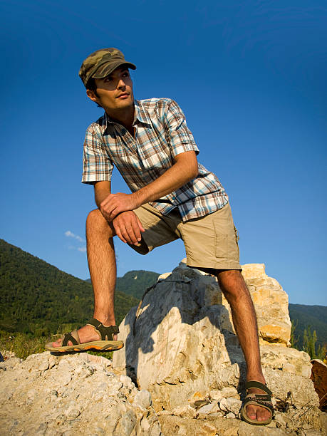 istock young man standing on rocks in mountains 481023485