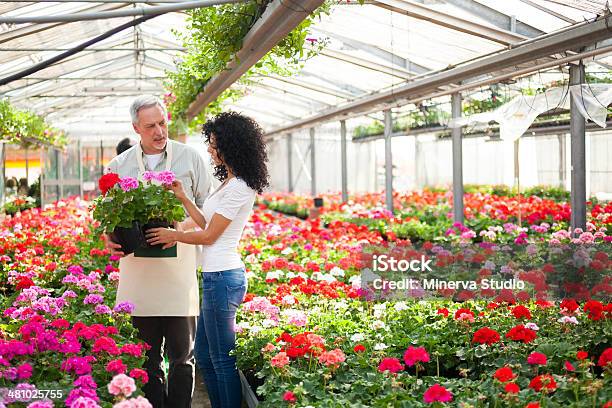 Greenhouse Worker Giving Aplant To The Customer Stock Photo - Download Image Now - Adult, Blue-collar Worker, Business