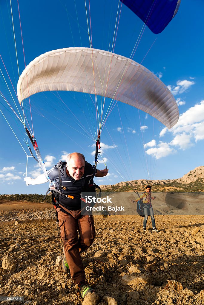 Paraglider take off Paraglider pilot taking off from the hill at the sunset Activity Stock Photo