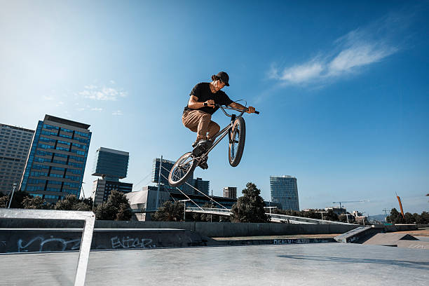 bmx fahrer springen in urbaner umgebung - bmx stock-fotos und bilder