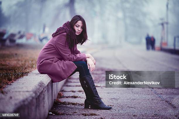 Traurige Junge Frau Sitzt Im Freien Stockfoto und mehr Bilder von Abwarten - Abwarten, Betrachtung, Depression