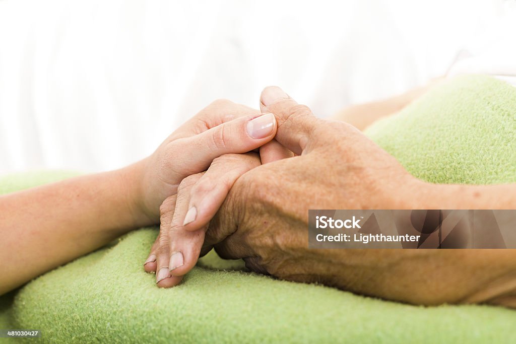 Helping the Needy Health care nurse caring for elderly concept - holding hands. Adult Stock Photo