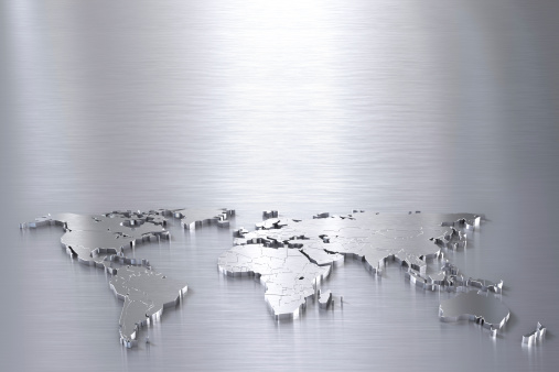 Silver world map on brushed metal surface.