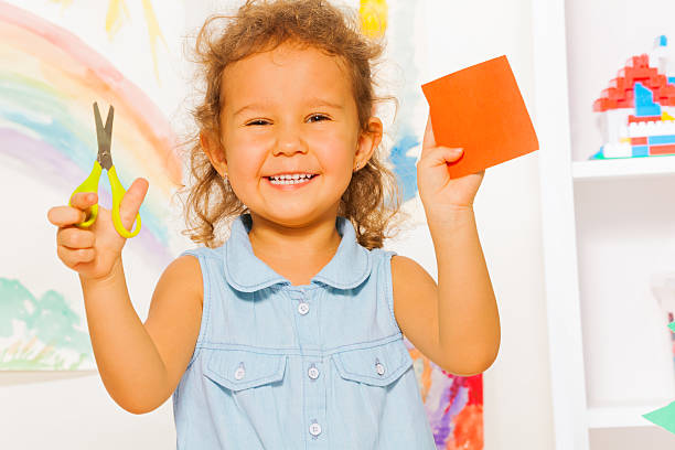 istock Smiling little girl with scissors and square 481034582