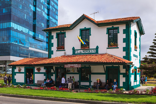 Bogota, Colombia - June 15, 2013: The Usaquen Train Station from which the 'Tren Turistico' or translated, Tourist Train, departs every Saturday, Sunday and public holiday for the Sabana de Bogota; there are extensions to the trips in the Sabana, to either the Salt Cathedral in the halite mines at Zipaquirá or the salt mines in Nemocón - photo shows passengers waiting for the train to arrive on a Saturday morning. Shot in the morning sunlight; horizontal format.