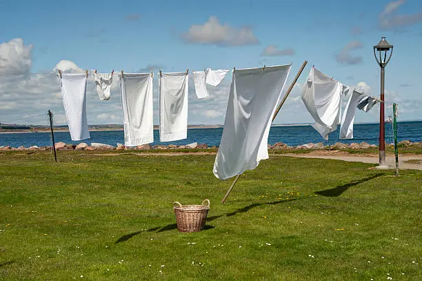 capture of a clothesline full of freshly laundered bright whites drying in a gentle breeze 