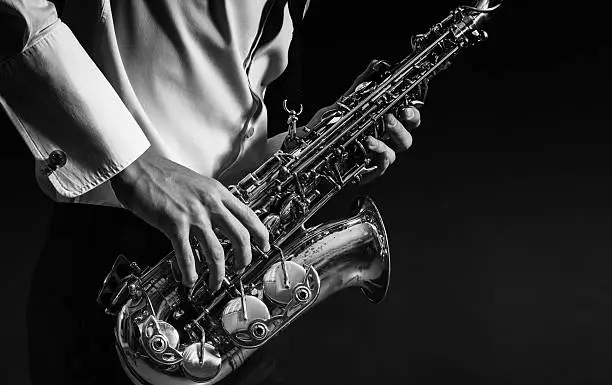 A man plays the saxophone close up.