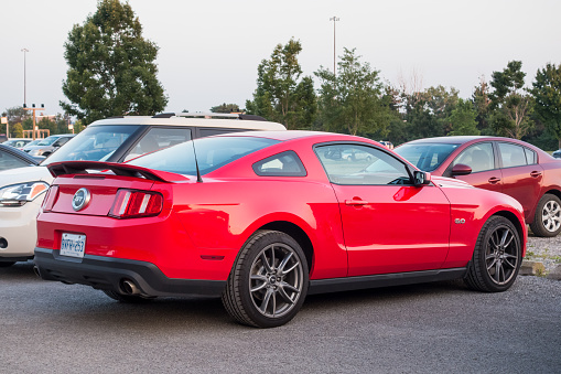 Hamilton, Canada - July 22, 2014: A red colored Ford Mustang GT Coyote with 5.0L engine parked in a parking lot.