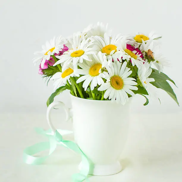 Bouquet of garden flowers in rustic white mug