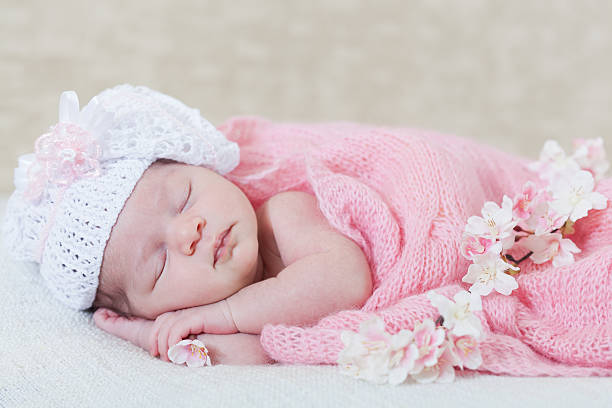 istock newborn girl sleeps with spring flowers 481053799