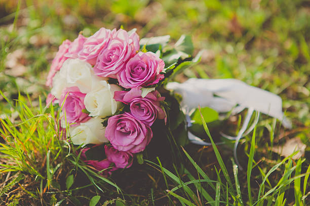 istock wedding bouquet of pink and white roses lying on grass 481054664