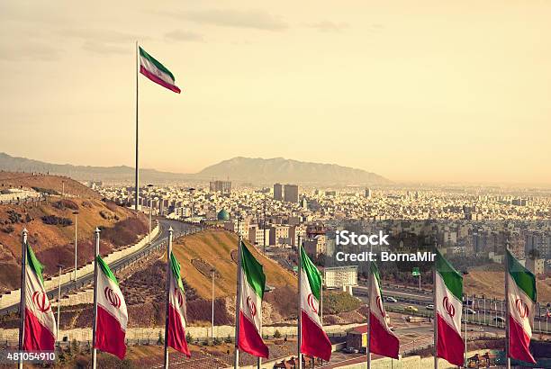 Row Of Iran Flags In Front Of Tehran Skyline Stock Photo - Download Image Now - Iran, Tehran, Flag
