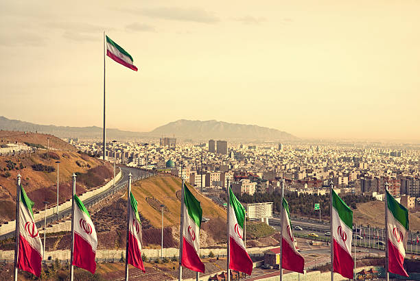 fileira de irão bandeiras na frente do horizonte de teerão - iran - fotografias e filmes do acervo