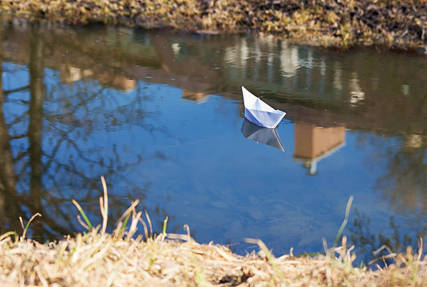 istock paper boat floating in the creek 481055653