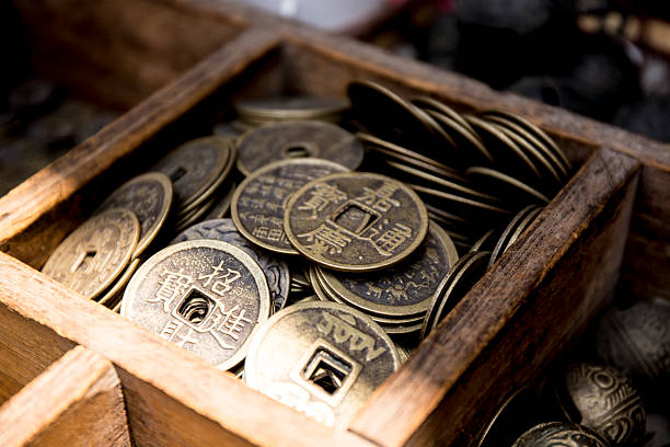 Chinese Coin, Good Fortune Wooden box containing assorted ancient Chinese coins, used to encourage good fortune. Coins displayed for sale on table.  chinese yuan coin stock pictures, royalty-free photos & images