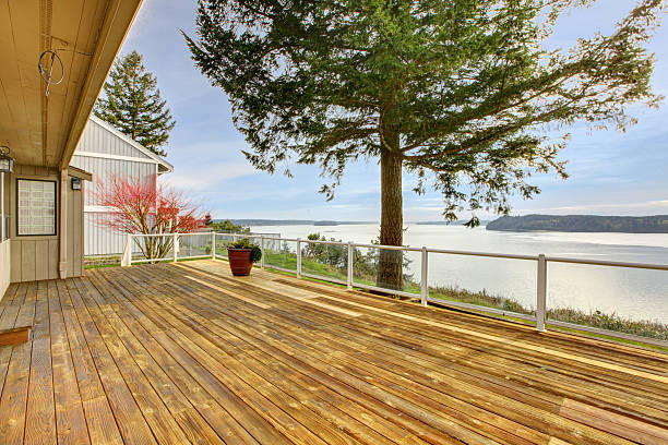 istock Home Wood porch with water view and pine trees. 481060215