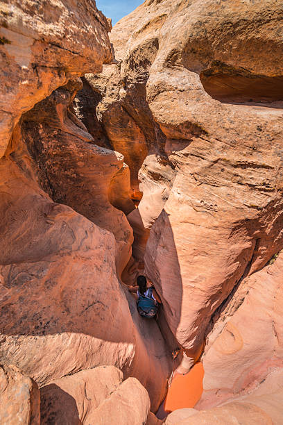 istock Girl Hiker Backpacker Climbing down the Slot Canyon 481061024