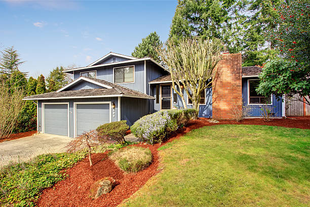 istock Beautiful blue home with large yard containing grass and soil. 481068520