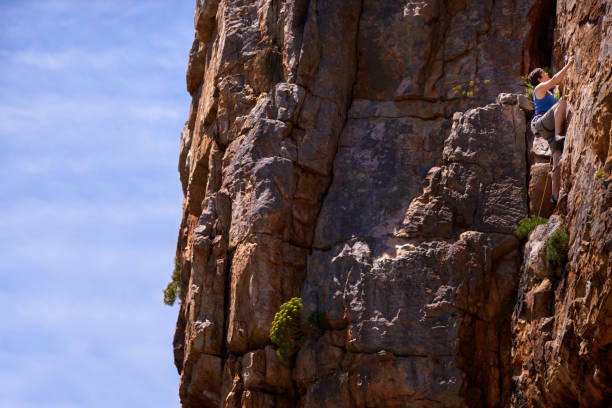 Shot of a female climber scaling a rock face