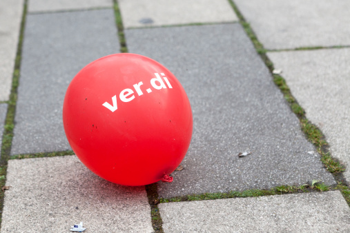 Wiesbaden, Germany - March 19, 2014: A red balloonwith the logo of verdi is lying on the ground during a warning strike and demonstration for higher wages in public services in the city center of Wiesbaden, Germany. The demonstration was organized by german trade union verdi.