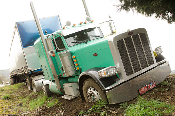 semi truck drives off the road Winston, OR, USA - February 27, 2012: Large semi truck drives off the road and nearly rolls over following a driver medical problem truck in rain stock pictures, royalty-free photos & images