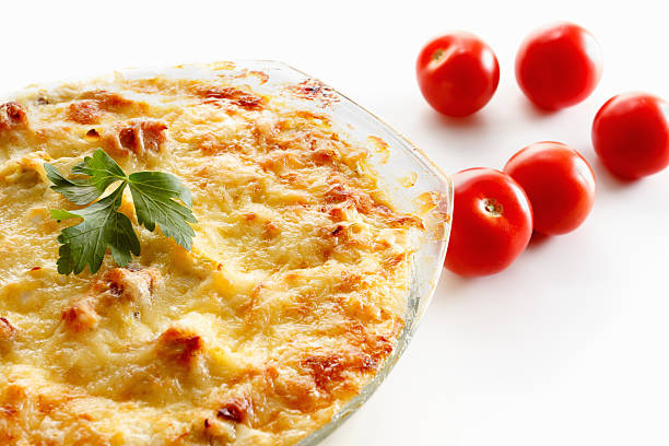 Baked squash with meat, cherry tomatoes and herbs in a glass pot.  Closeup studio shot