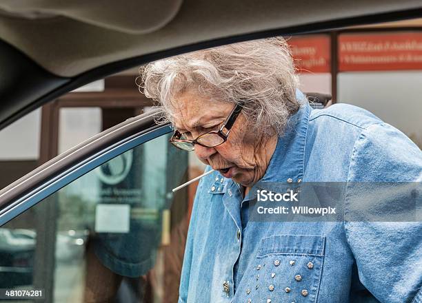 Photo libre de droit de Mamie Sucer Lollypop Tout En Se Déplacer En Voiture banque d'images et plus d'images libres de droit de Embarquer