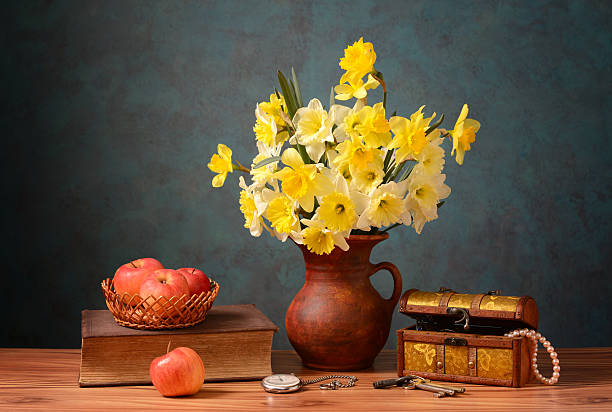 A deep blue conzinochka with white nectarines and a bouquet of daisies in a blue vase on a wooden table in a village room