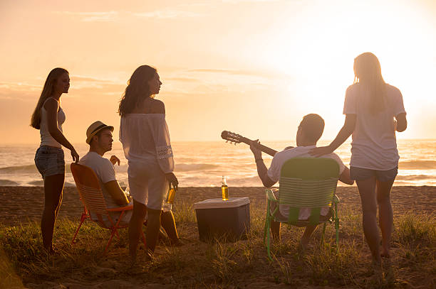 istock Relaxed friends beach party at sunset 481074533