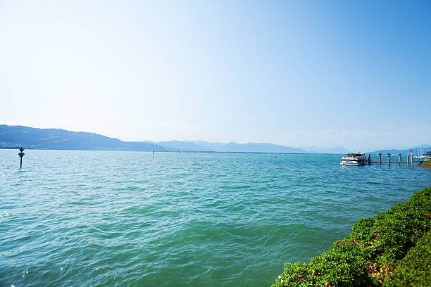 Lindau, Germany - July 11, 2015: Lake Bodensee at summertime in midsummer, view fro island Lindau. At right side is tourboat. In background is Switzerland.