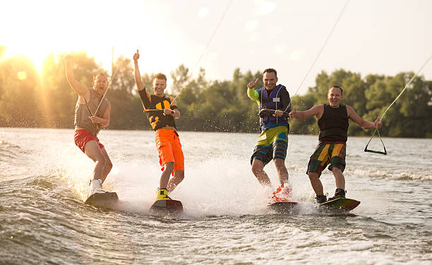 четыре wake bord riders весело - wakeboarding стоковые фото и изображения