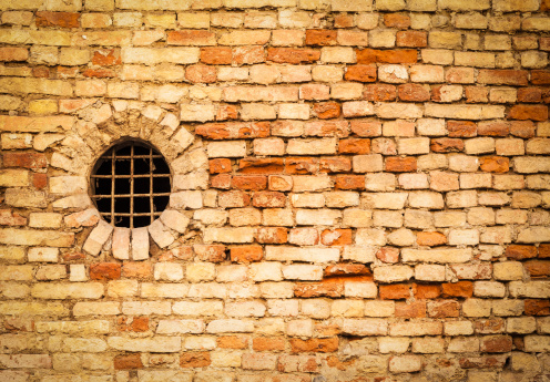 Old brick facade with a round window.