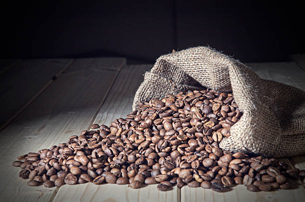 istock Burlap sack full of coffee beans on the wood table 481079311
