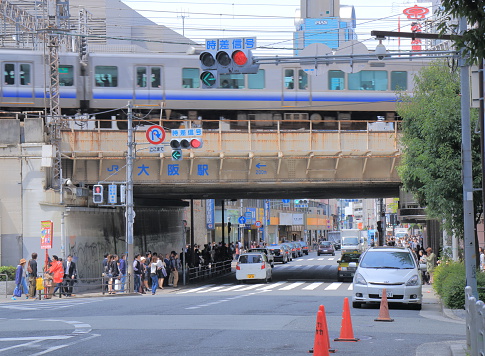 Osaka Japan - April 24, 2015: People walk under train rail crossing bridge in Osaka Japan.