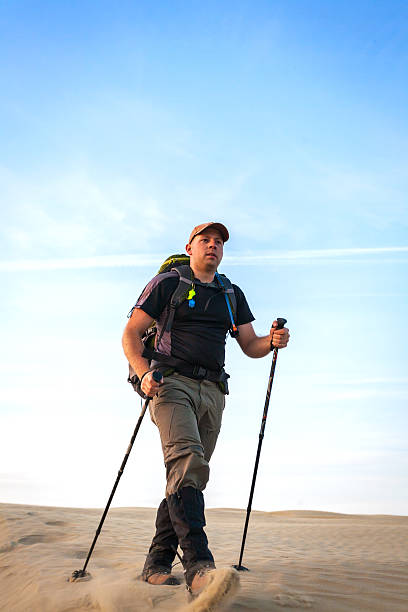 Man With Backpack Hiking In The Desert