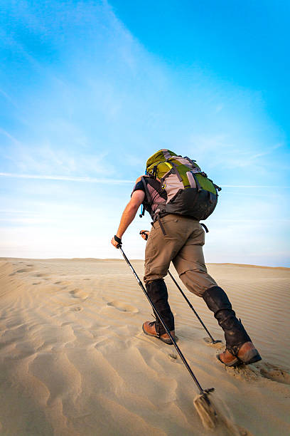 Man With Backpack Hiking In The Desert