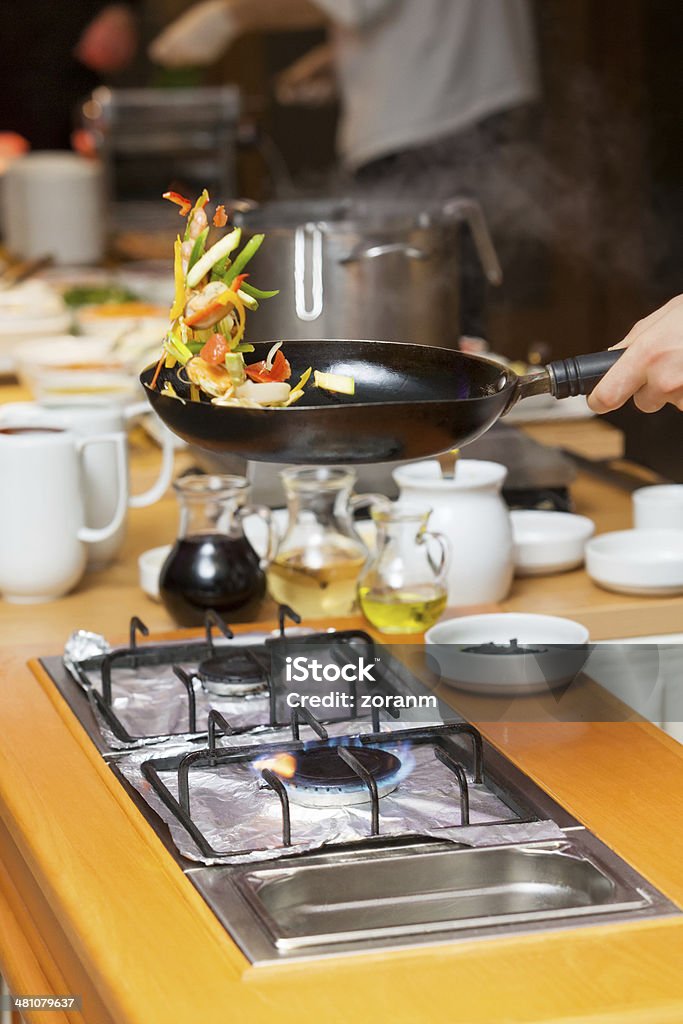 Cooking Chef preparing food,  fresh ingredients mid-air, in frying pan Chef Stock Photo