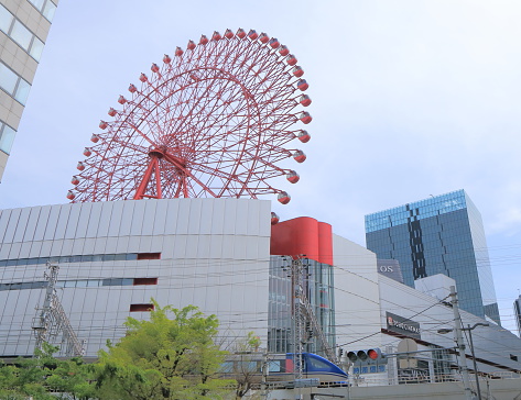 Osaka Japan - April 24, 2015: Contemporary architecture of Hankyu Umeda department store and ferris wheel in Osaka Japan.