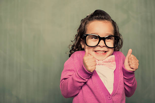 Thumbs Up A young nerdy girl is giving the thumbs up, because everything is a-okay. nerd kid stock pictures, royalty-free photos & images