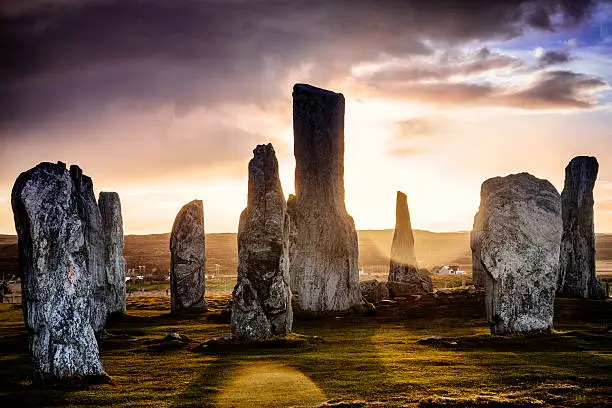 The ancient standing stones of Callanish (or Calanais) on Lewis in the Outer Hebrides of Scotland at sunrise on a stormy spring morning. Built about 5000 years ago, the deeply textured stones of Callanish are arranged in allignments of avenues and a central circle not unlike a celtic cross.