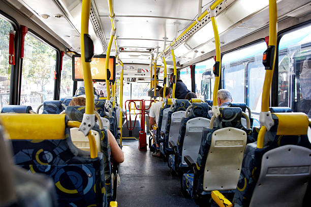 Bright and clean interior of a transit vehicle with empty red seats and large windows, creating a spacious atmosphere.