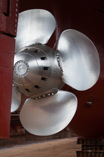 Main propeller and stern of a industrial ship at the dry dock in shipyard.