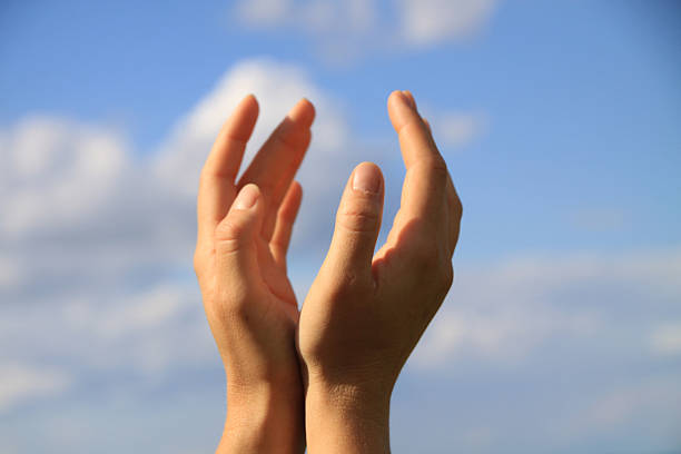 Young woman hand reaching for mountains. Spiritual girl smiling to sky. Happy female being thankful. Spiritual girl praying with hope. Positive asian young woman feeling hope and faith looking up.