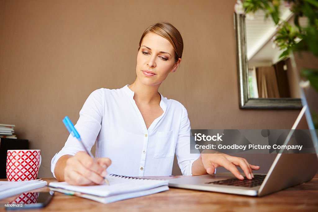 She's a great multi-tasker Shot of a young businesswoman writing something down while working on her laptop at homehttp://195.154.178.81/DATA/i_collage/pu/shoots/805292.jpg 30-39 Years Stock Photo